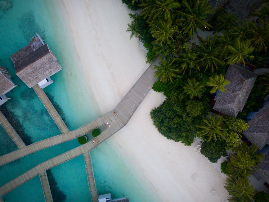 A stunning aerial view of a tropical beach resort with turquoise waters and lush greenery